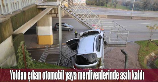 Yoldan çıkan otomobil yaya merdivenlerinde asılı kaldı